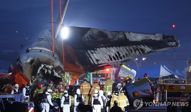  29일 오후 전남 무안군 무안국제공항에서 발생한 제주항공 여객기 충돌 폭발 사고 현장에서 파손된 기체 후미가 크레인으로 옮겨<br>
지고 있다. 2024.12.29 【무안=연합뉴스】