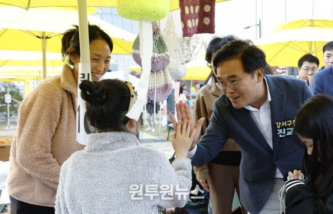 진교훈 서울 강서구청장(오른쪽)이 25일 발산근린공원에서 열린 ‘발산마을축제’에서 플리마켓에 참여한 아이와 손을 맞대고 있다.