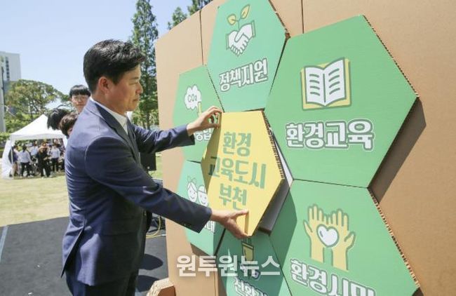 조용익 부천시장이 환경교육한마당에서 선언 퍼즐에 환경교육 키워드를 부착하는 모습