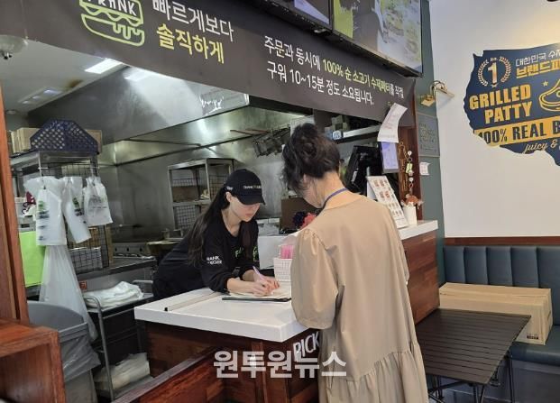 성남시 어린이 기호식품 전담관리원이 지난 9월 학교 주변 햄버거 판매점에서 영업자와 종업원의 건강진단 실시 여부를 점검하고 있다