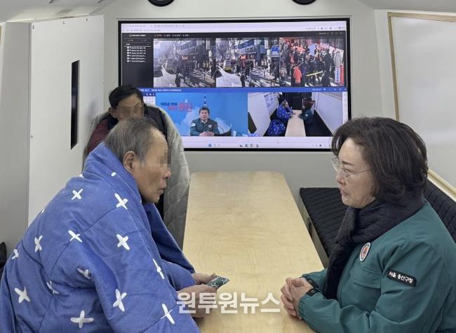 박희영 용산구청장이 재난현장지휘버스에서 임시대피 중인 청파동 화재 피해 주민들의 안전 상태를 살피고 있다.