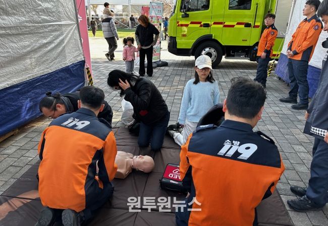 제54회 강진청자축제 119안전체험장에서 어린이와 부모님이 함께 심폐소생술을 배우고 있는 모습.