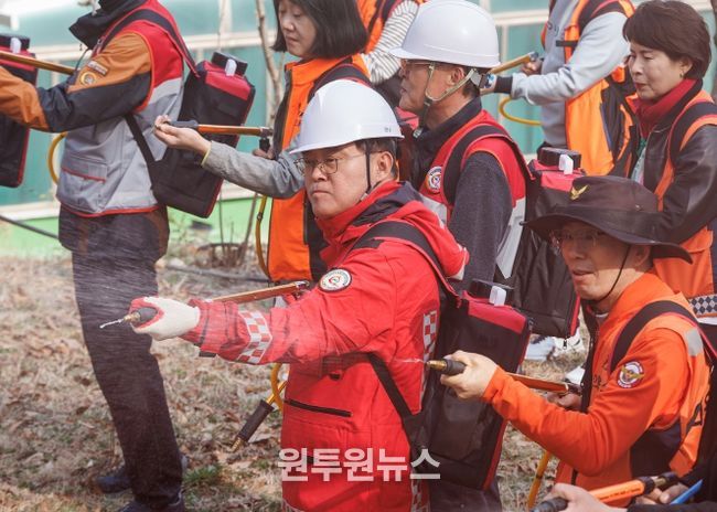 진교훈 서울 강서구청장(가운데)이 25일(수) 개화산 약사사에서 열린 ‘유관기관 합동 산불진압훈련’에서 등짐펌프를 매고 잔불진화작업을 하고 있다.