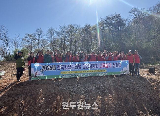 한국자유총연맹 밀양시지회 회원들이 나무심기 행사를 개최하고 기념 촬영을 하고 있다.